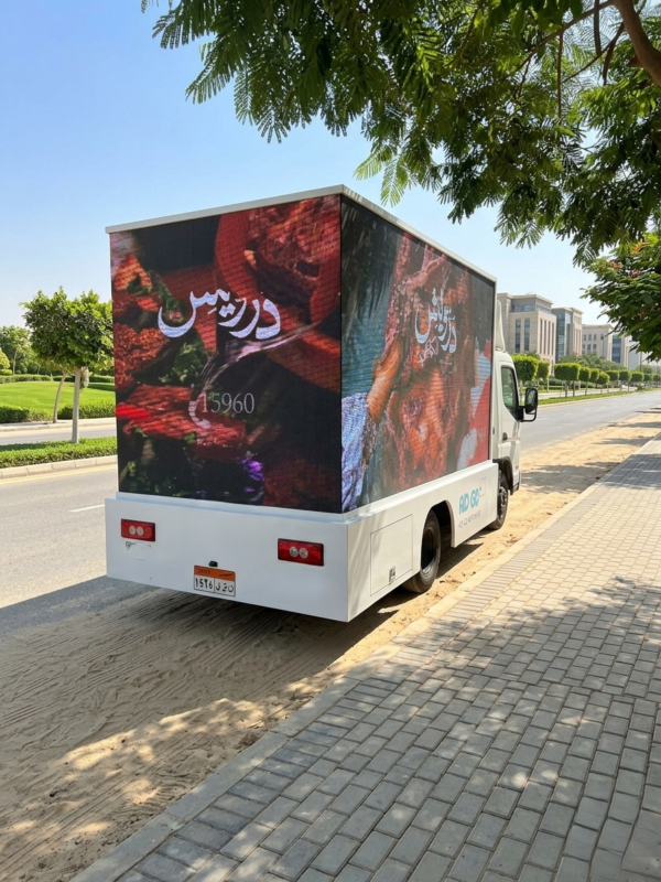 شاشة LED إعلانية مثبتة على سيارة نقل تعرض إعلانات تجارية أثناء التجول في شوارع المدينة.