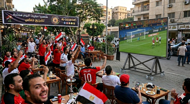 شاشة SCENO متنقلة تعرض مباراة كرة قدم لجمهور داخل كافيه بأجواء حماسية