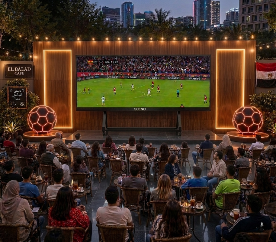 مشجعون يتابعون مباراة كرة قدم عبر شاشة SCENO LED داخل كافيه بأجواء حماسية.
